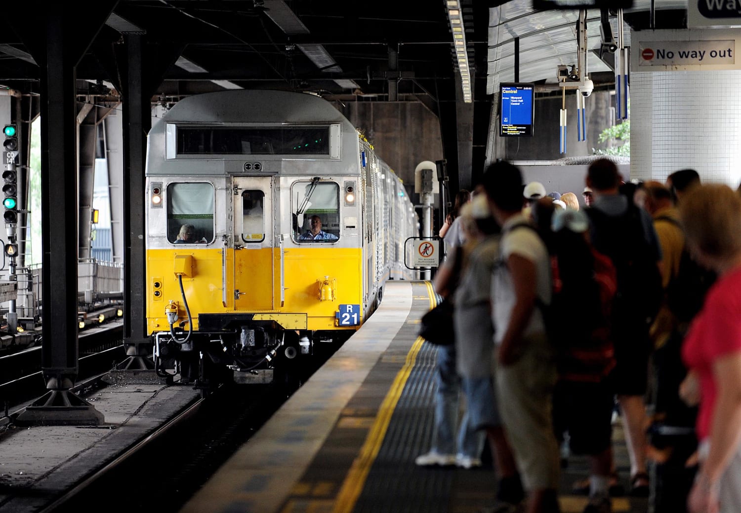 Commuters wait as a New South Wales Government CityRail commuter train 