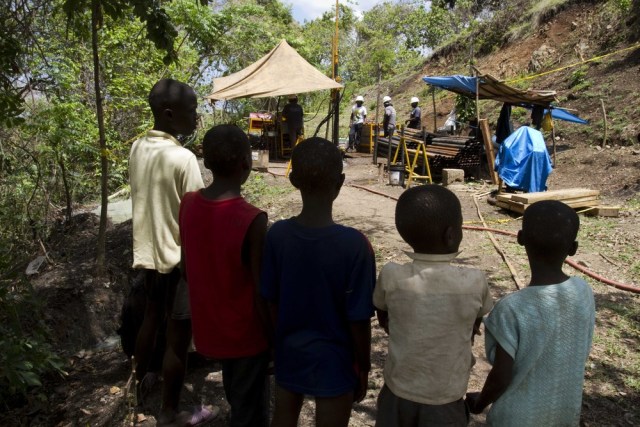 Image: Haitian children watch gold drilling