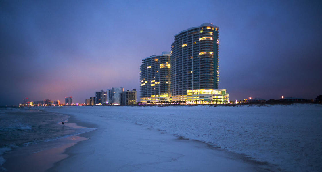 Image: The Turquoise Place condominium buildings rise above Orange Beach, Alabama, before sunrise.