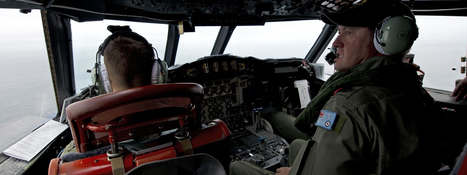 Image: A Royal Australian Air Force flight engineer aboard a AP-3C Orion aircraft keeps watch for any debris 
