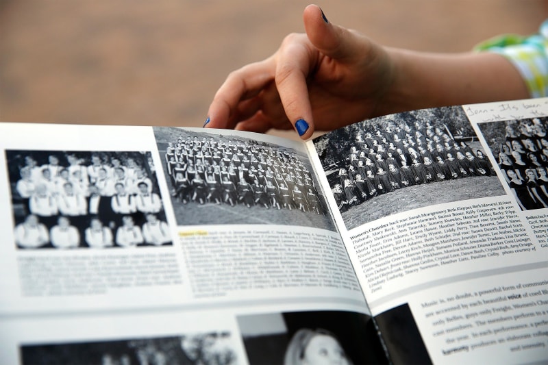 Image: Former Columbine High School students Jennifer Hammer points out their choir group picture in her yearbook to Heather Egeland at the Columbine Memorial