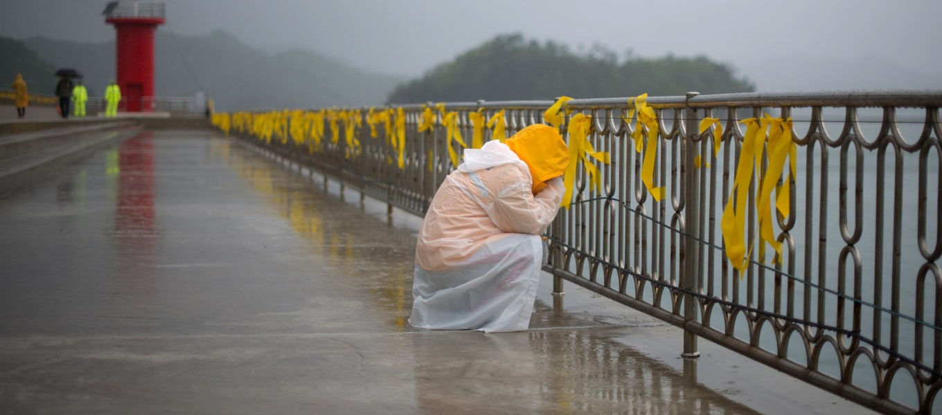 Image: A relative weeps before yellow ribbons at Jindo harbor 