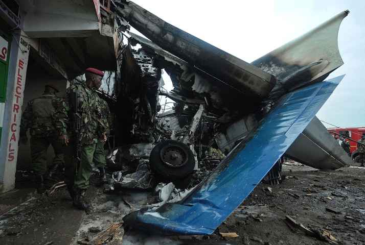 Image: Kenyan army men stand near the wreckage of a cargo plane