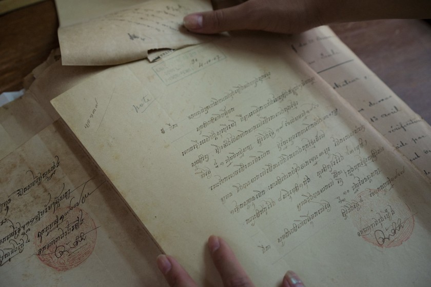 Image:  Cheryl Yin studies an old document in the National Archive of Phnom Penh