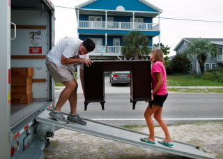 Image: Legge helps his sister-law remove furniture from the lower level of her beachfront home in anticipation of Hurricane Matthew in Garden City Beach