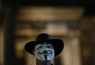 Image: A supporters of the activist group Anonymous wears a mask during a protest in London, Britain.