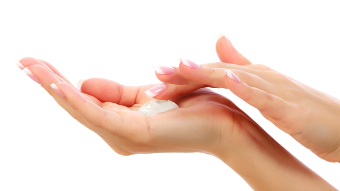 Female hands with a moisturizer cream on white background<br /><br /><br /> 