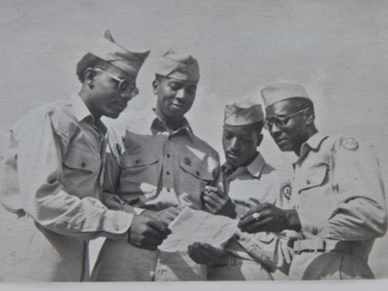 Wilson Monk (third from left) and other men from the 320th appear to be in deep thought as they peruse a document.