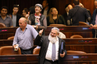 Image: Deputy Minister in the Ministry of Defense, Eli Ben-Dahan and other Israeli lawmakers gesture 