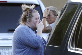 Image: Women react outside the First Baptist Church after several church members died in a crash