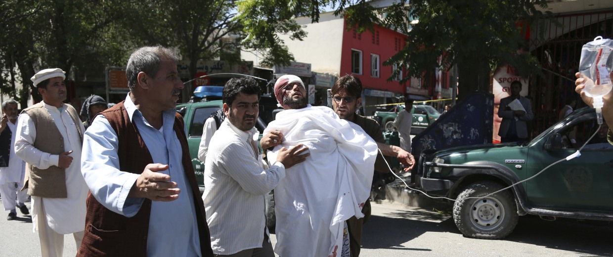 Image: People carry an injured man after a suicide attack in Kabul