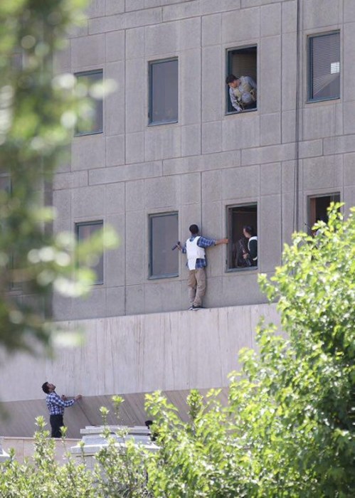 Image: Members of Iranian forces take position during an attack on the Iranian parliament in central Tehran