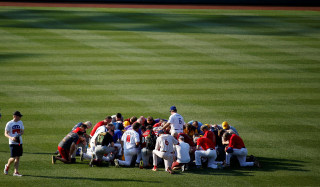 Image: Members of the Republican team pray before the Democrats and Republicans face off in the annual Congressional Baseball Game at Nationals Park in Washington