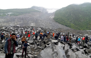 Image: Rescuers at the site of the early morning disaster in Maoxian county, China's Sichuan province.