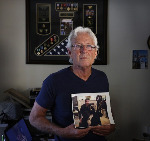 Image: William Owens holds a photo of his youngest son Navy SEAL William "Ryan" Owens in Lauderdale by the Sea, Florida.