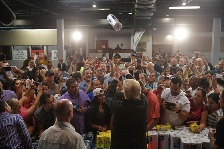 Image: President Donald Trump tosses a roll of paper towels into a crowd