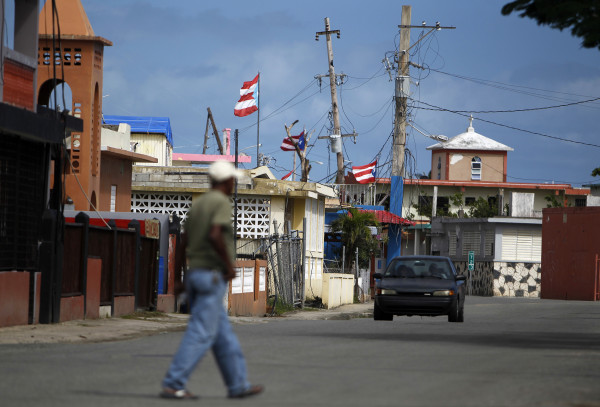 Image: A man crosses a street in the Punta Santiago beachfront neighborhood of Humacao