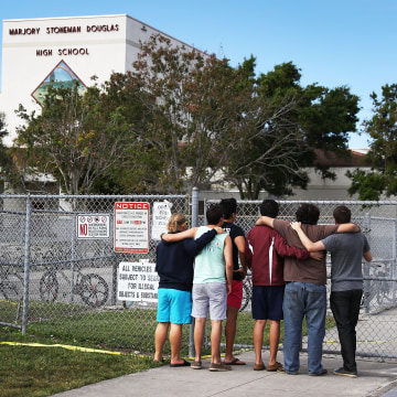 Image: People look on at the Marjory Stoneman Douglas High School
