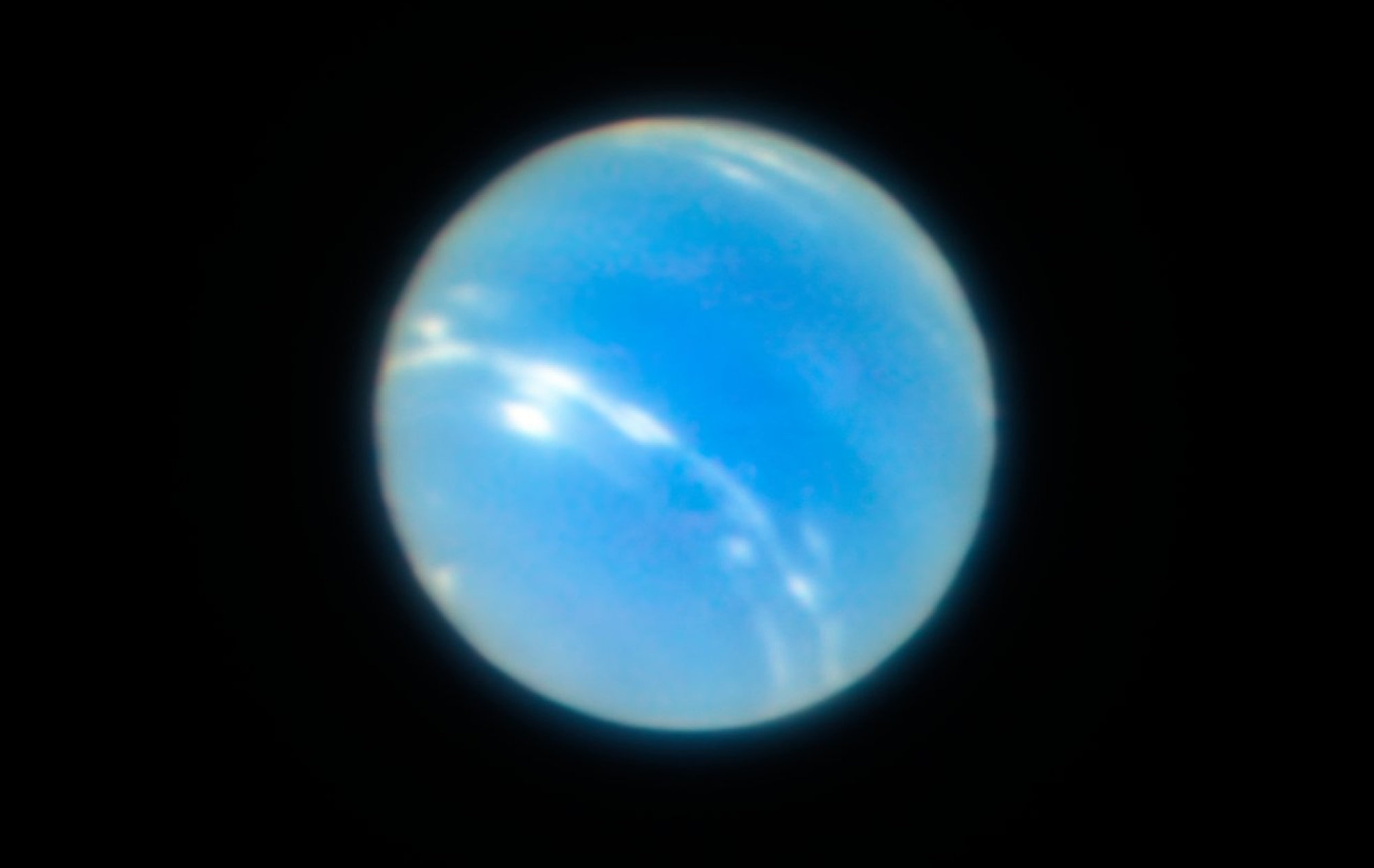 Image of the light-blue planet Neptune against black background