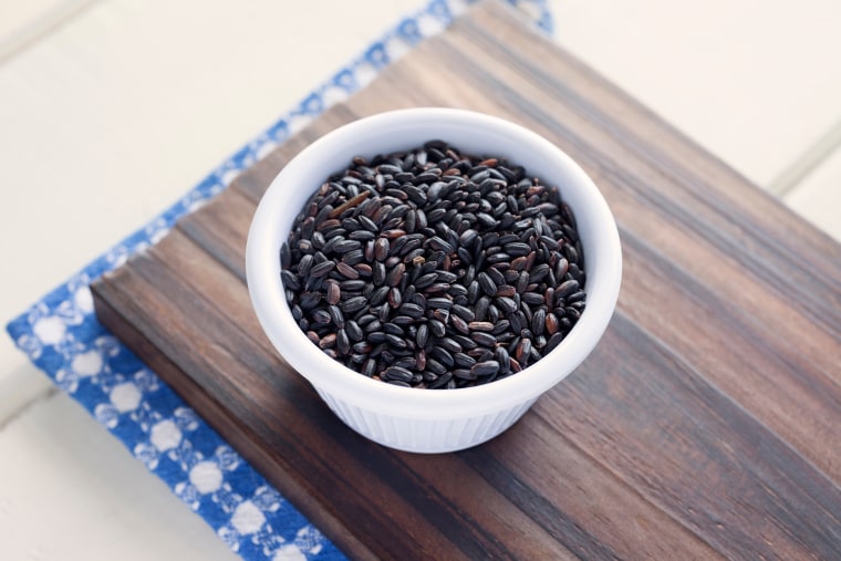 Close-Up Of Black Rice In Bowl On Cutting Board