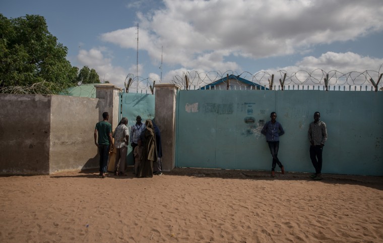 Image: Refugees crowd around a UNHCR field office in the Dadaab refugee camp.