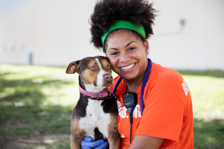 A Best Friends Animal Society volunteer hugs a rescue dog.
