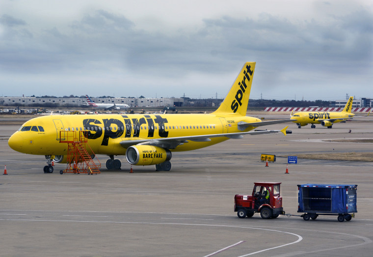 A Spirit Airlines plane is parked on the tarmac at Dallas/Fort Worth International Airport