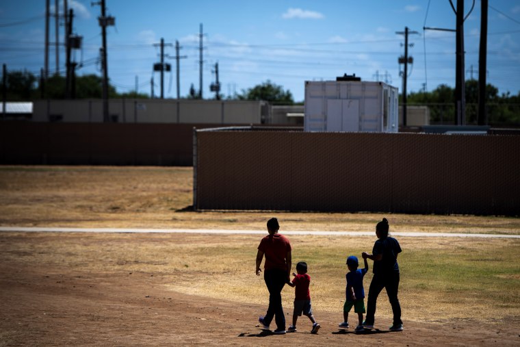 Image: Migrant women and children walk at the South Texas Family Residential Center in Dilley, Texas, on Aug. 23, 2019.