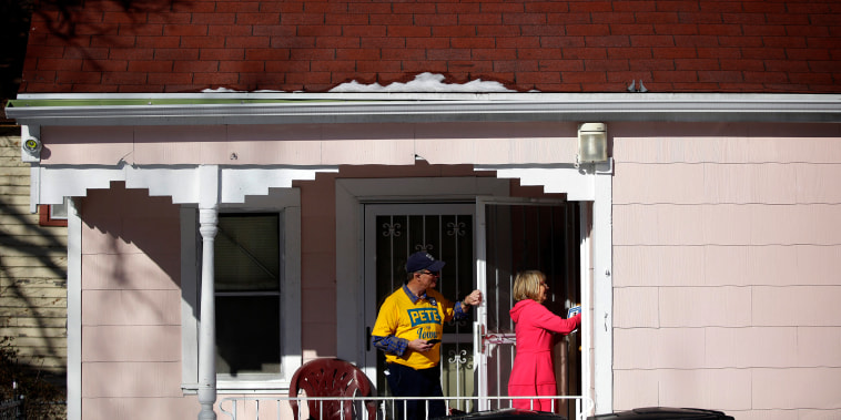 Image: Len Edgerly and Darlene Determan knock on a door while canvasing for Pete Buttigieg in Des Moines, Iowa, on Feb. 2, 2020.