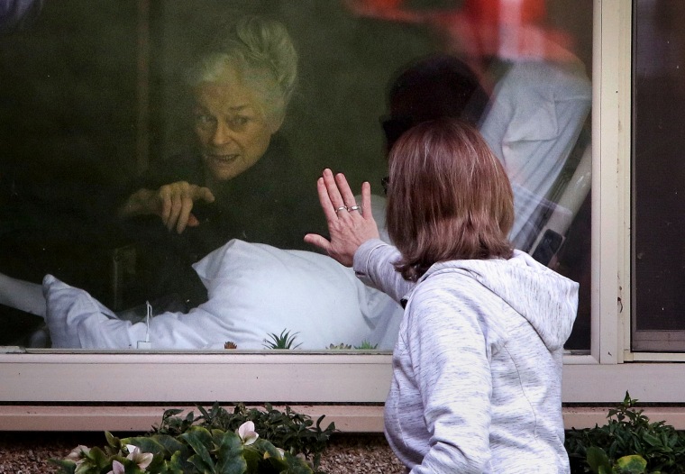 Image: Lori Spencer visits her mother, Judie Shape, who tested positive for coronavirus at the Life Care Center of Kirkland nursing home near Seattle, on March 11, 2020.