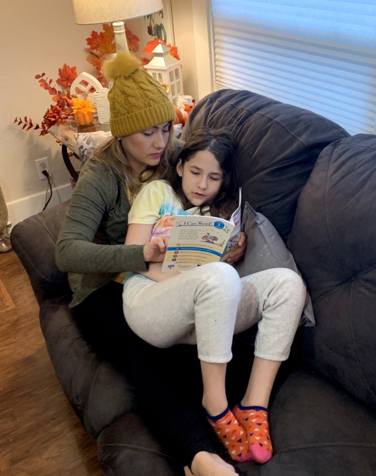 Image: Angelica Gonzalez and her daughter, Lolly, read on the couch at home.