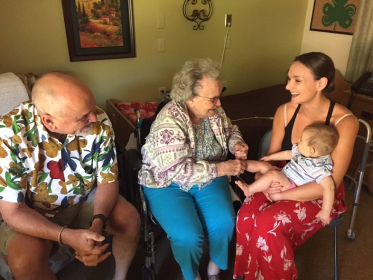 MaryAnn Zack, center, is pictured at the moment she met her grandson, Jack, for the first time. She later died of COVID-19 in a long-term care facility.